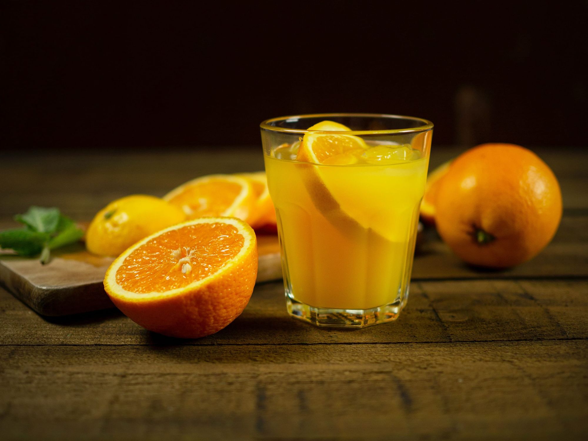 image of a glass of orange juice near a sliced orange