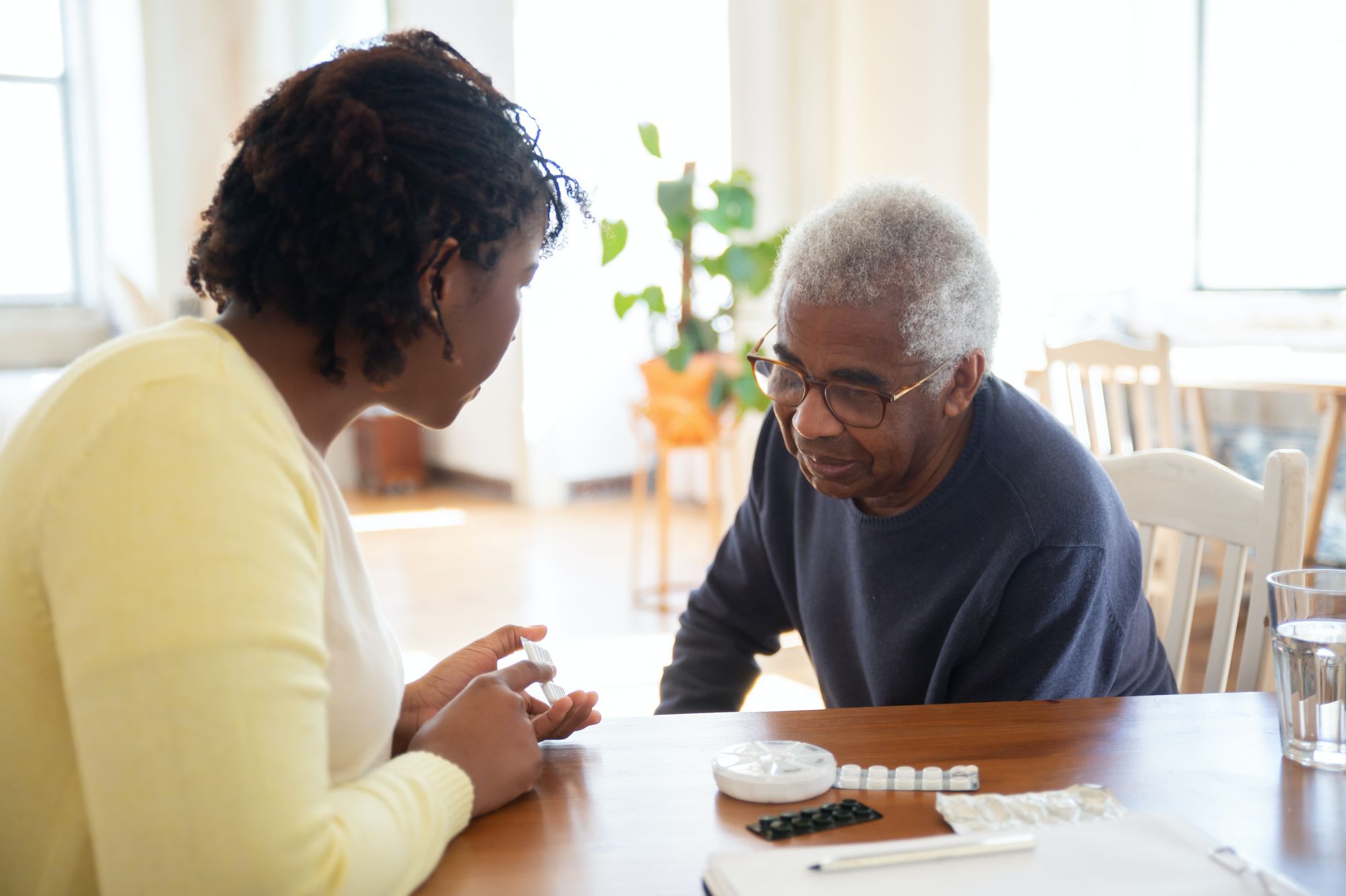 A woman explaining medications to an elderly person