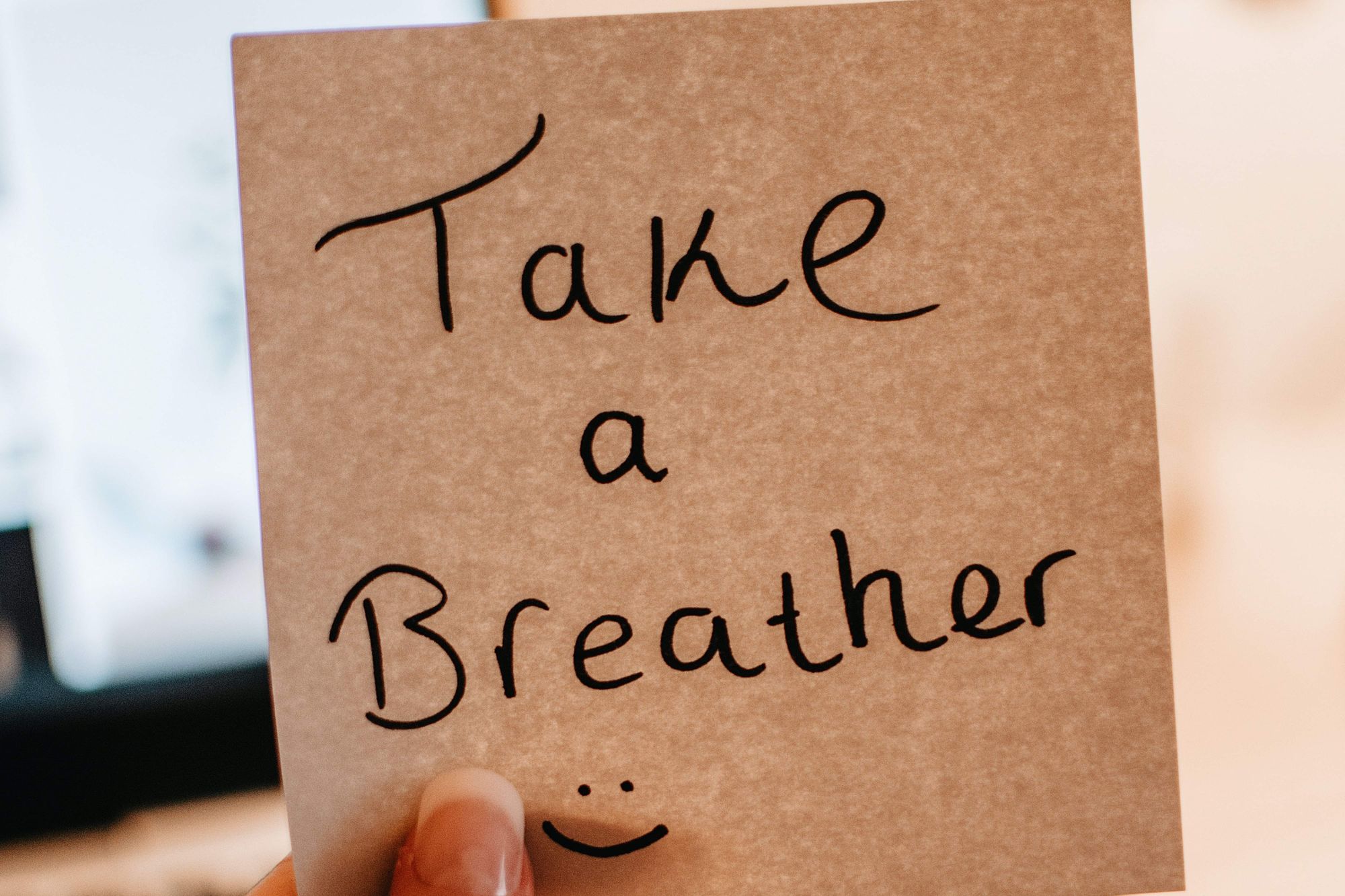 Image of a woman holding a paper with text "Take a breather"
