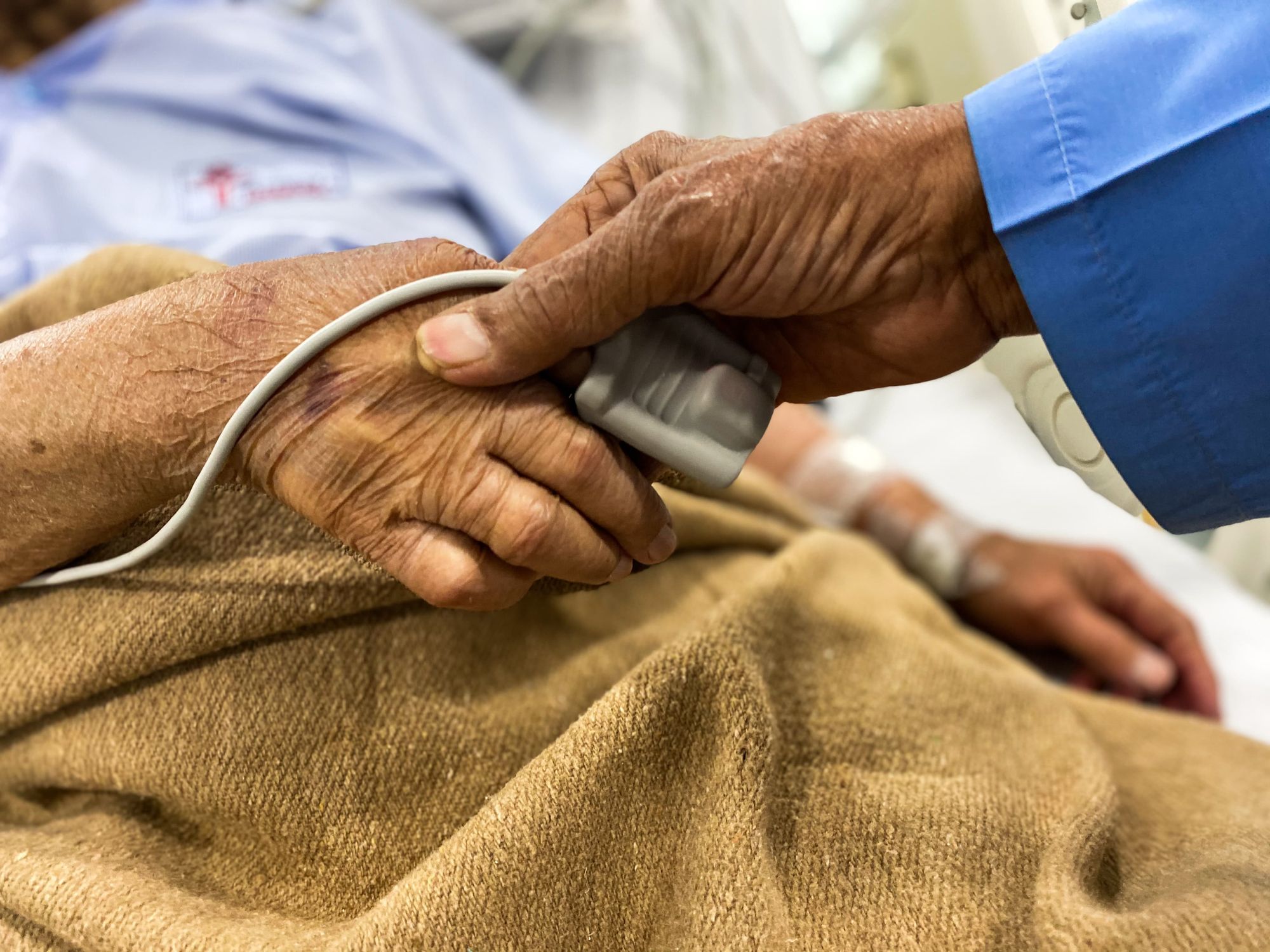 A person holding a sick patient's hand