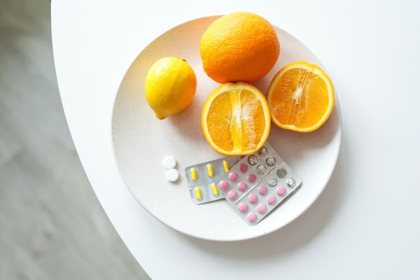 Image of orange fruit and medications on plate